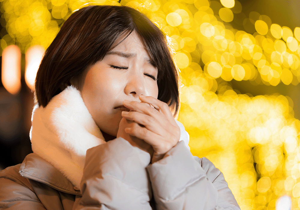 寒さで手がかじかむ女性